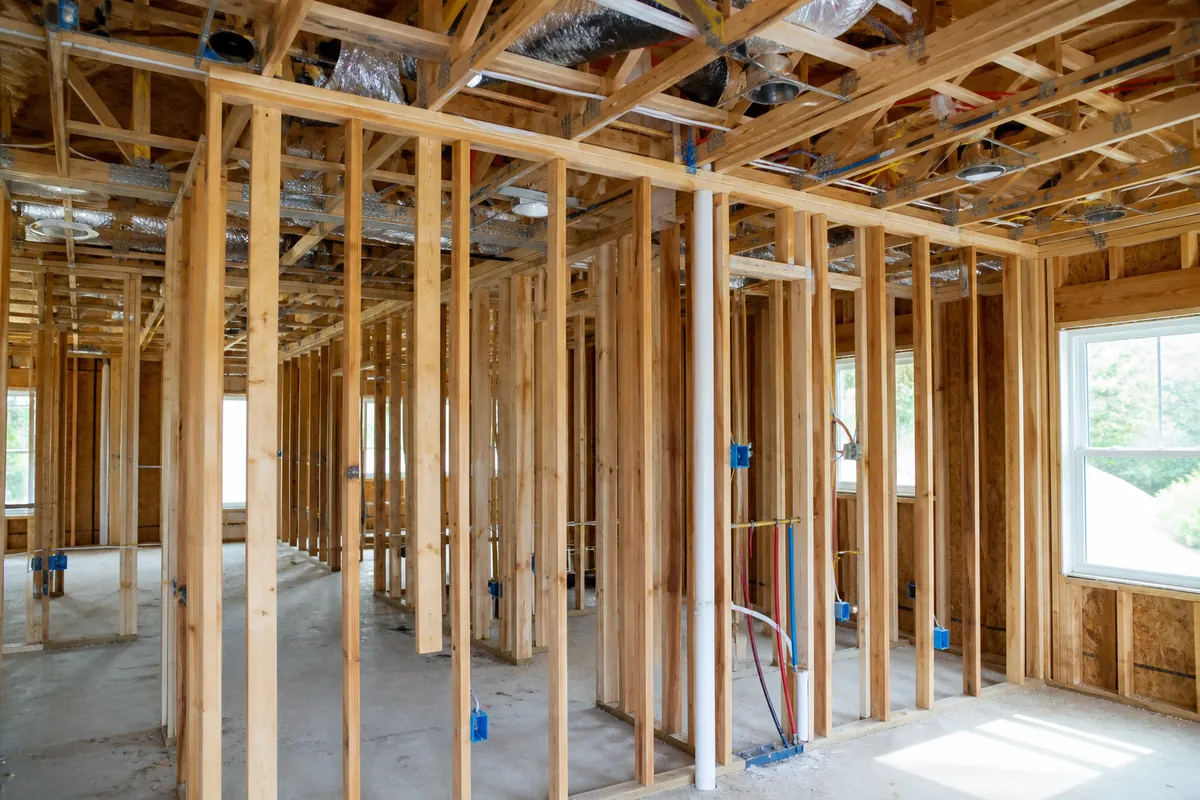 Open wood stud framing with electrical and HVAC rough-ins before drywall